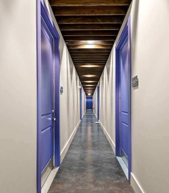 State Street Flats Apartments long hallway with blue doors and a wooden ceiling.