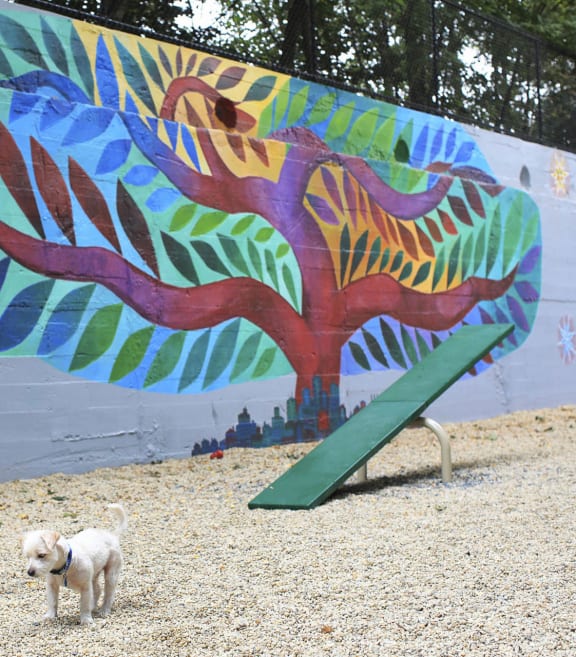 a dog standing next to a fire hydrant in front of a mural