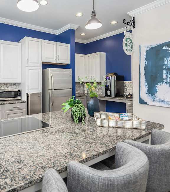 A kitchen with granite countertops and white cabinets.