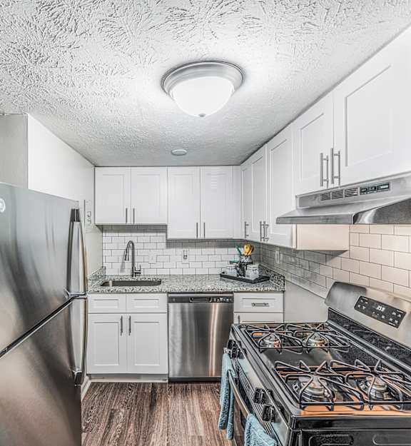 a kitchen with stainless steel appliances and white cabinets