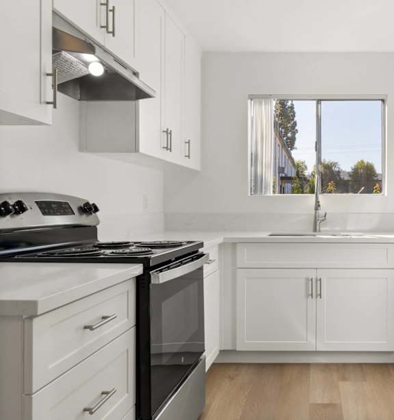 A modern kitchen with a stainless steel refrigerator and a white countertop.