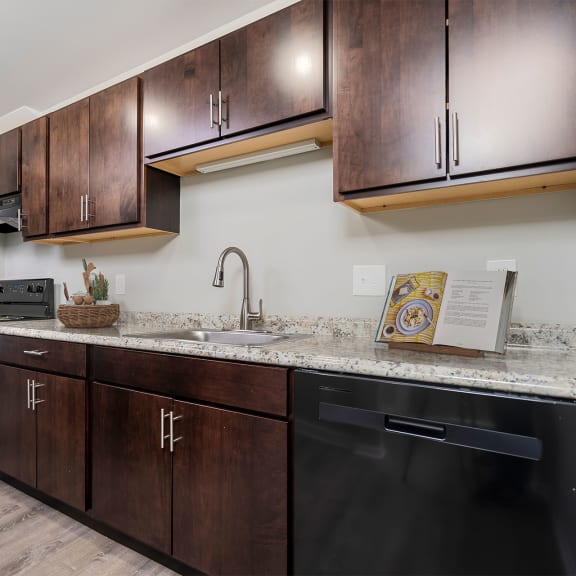 a kitchen with wooden cabinets and a counter top and a sink