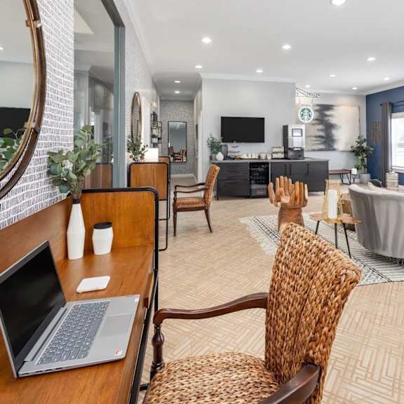 A modern living room with a laptop on the desk.