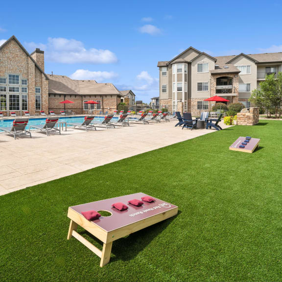 lawn with cornhole games at Red Hawk Ranch apartments
