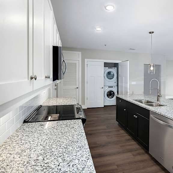 A modern kitchen with granite countertops and stainless steel appliances.