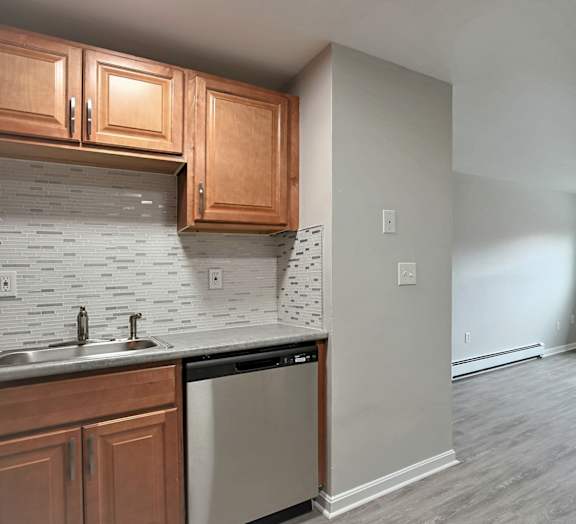 A kitchen with wooden cabinets and a dishwasher.