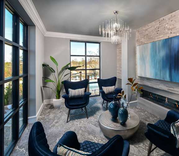 a living room with blue chairs and a fireplace