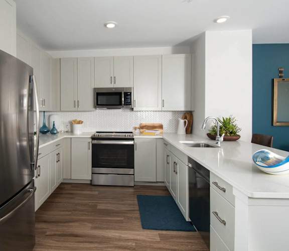 a kitchen with white cabinets and stainless steel appliances