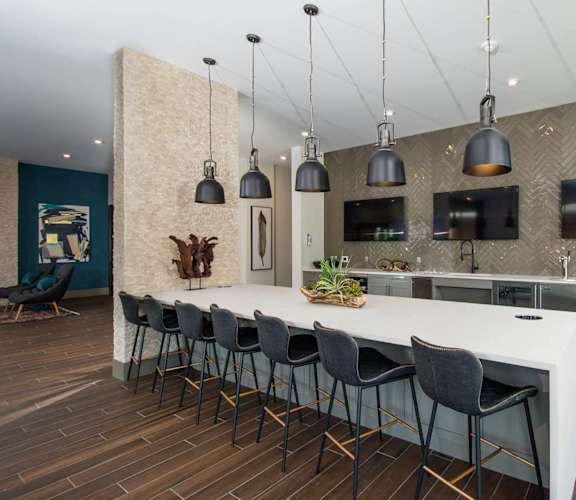a large kitchen with a white counter top and chairs