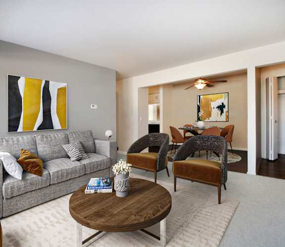 A living room with a grey couch, a coffee table, and a painting on the wall.