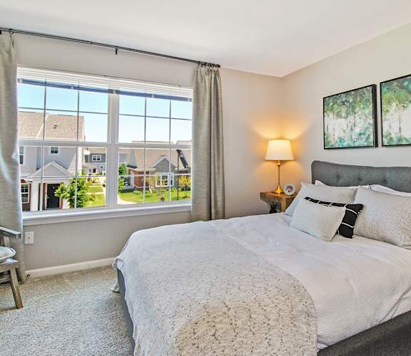 a bedroom with a large window and a bed