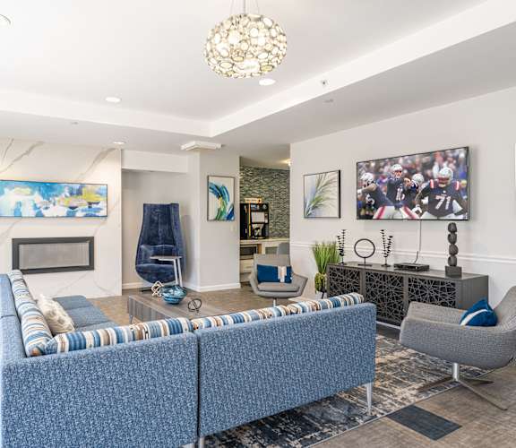 Parkside Commons community room with fire place and a blue sofa and a fireplace.