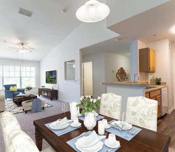 a living room with a dining table and a kitchen in the background