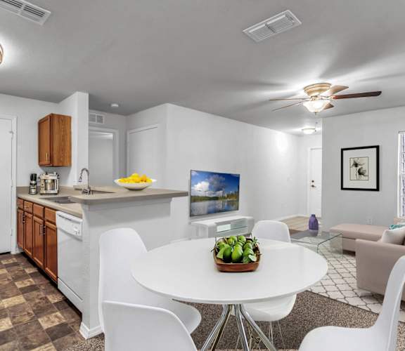 a kitchen and living room with a white table and chairs