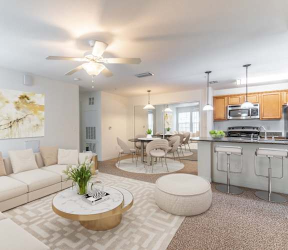 a living room with couches a coffee table and a kitchen in the background