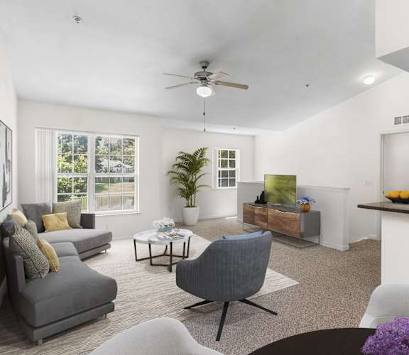 a living room with white walls and a ceiling fan