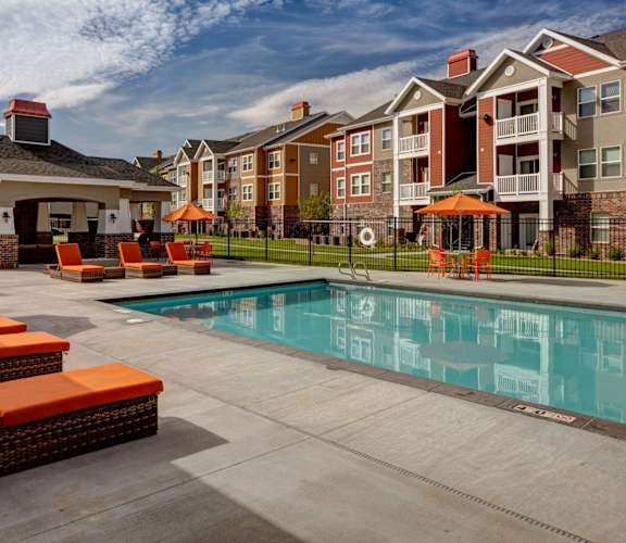 A pool area with orange chairs and a gazebo. at The Alloy at Geneva, Vineyard, UT, 84058