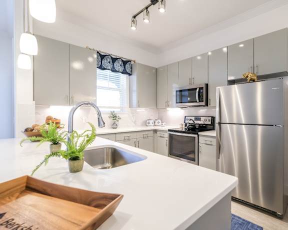 modern kitchen with stainless steel appliances at Reveal on the Lake luxury apartments