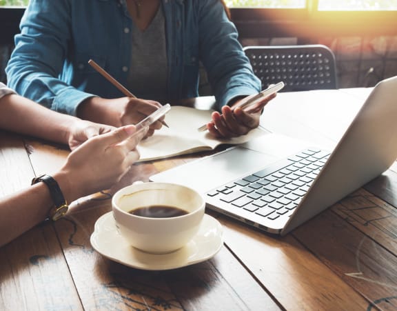 people sitting at a table with a laptop and a cup of coffee at Rivulet, Silverdale Washington
