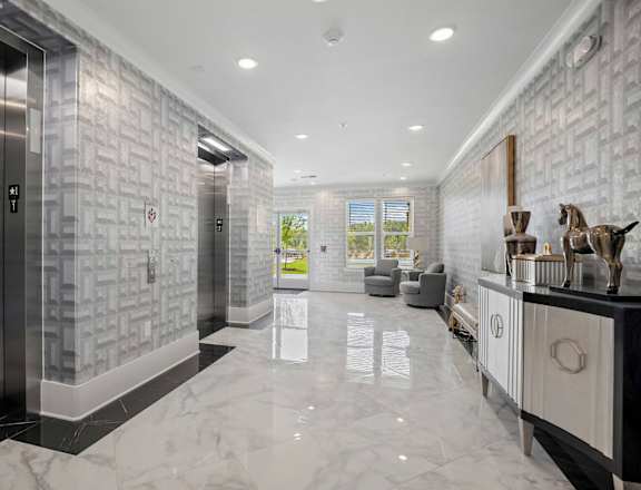 A modern hallway with a marble floor and a stone wall at Ellis Station, Durham, NC