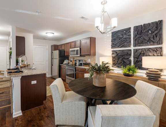A modern kitchen with a dining table and chairs.