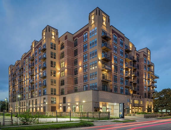 a rendering of a large apartment building at dusk