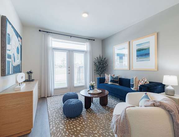 A living room with a blue couch and a white chair.