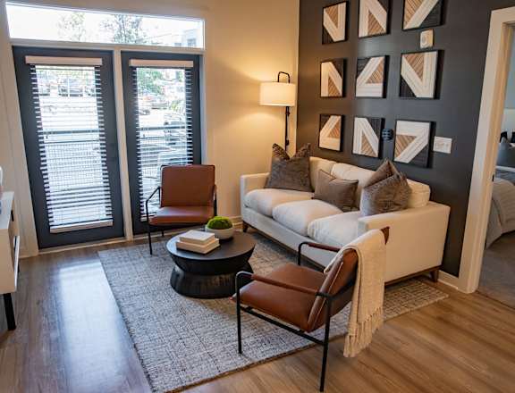 A living room with a white couch, a coffee table, and a lamp at Sterling Nashville West Apartments, Nashville, Tennessee