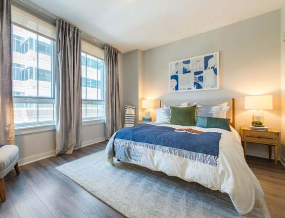 a bedroom with a bed and two windows