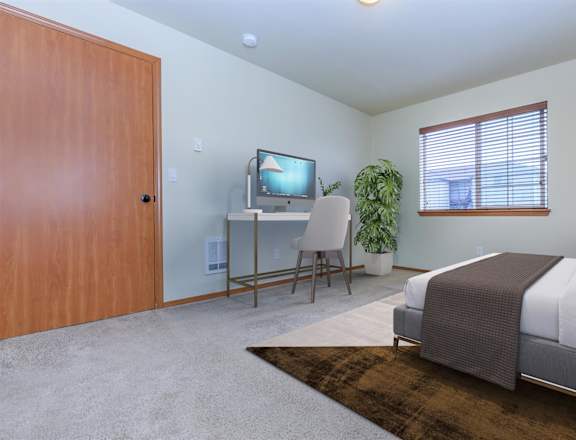 a bedroom with a bed and a desk with a tv