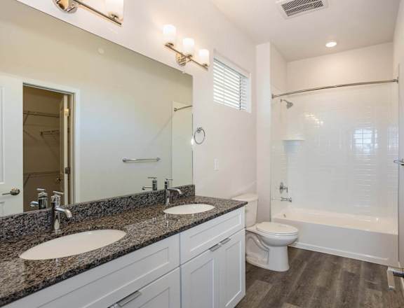 a bathroom with two sinks and a shower and a toilet at Brownstones at Palisade Park, Broomfield, 80023