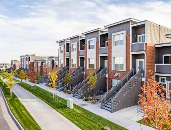 a row of townhouses with stairs and grass at Brownstones at Palisade Park, Broomfield, 80023