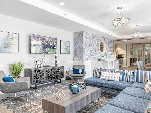 Parkside Commons community room with a grey armchair, a wooden coffee table, and a blue sofa.