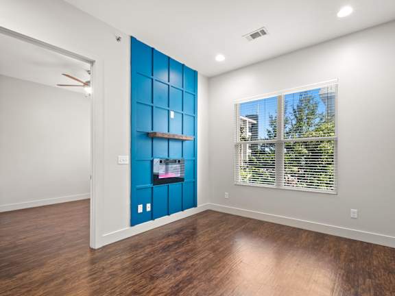 A room with a blue wall and wooden floors.