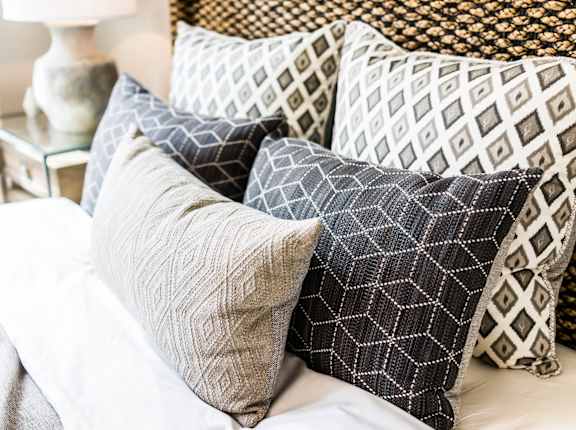 a pile of pillows on top of a bed