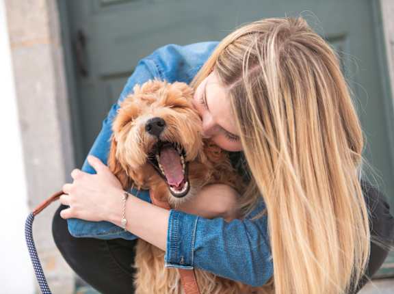 Woman Hugging Small Dog