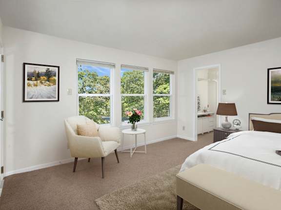 A bedroom with a large bed, a chair, and a painting on the wall.