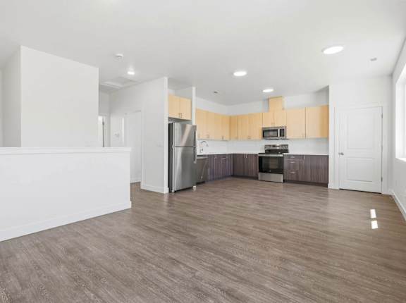 A kitchen with wooden floors and white walls.