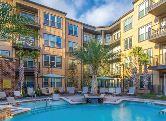 A large apartment complex with a pool in the foreground.