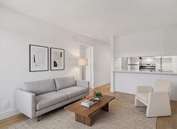 A living room with a grey couch, a coffee table, and a chair.