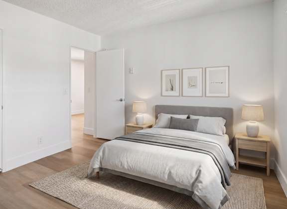 A bedroom with a large bed and two nightstands.
