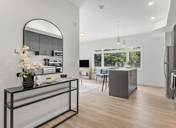 A modern kitchen with a large island and a fridge.