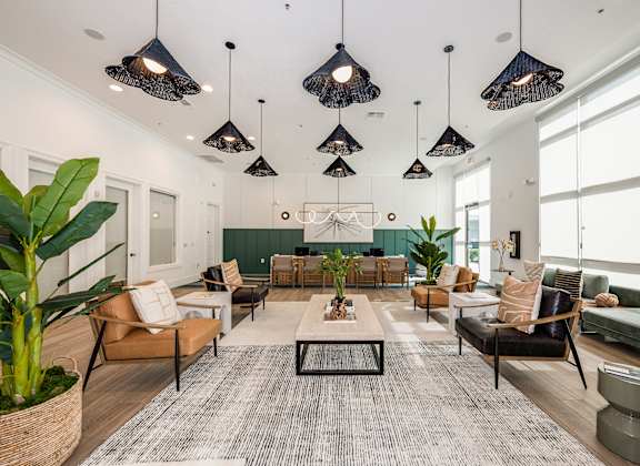 A modern living room with a large rug and a variety of seating options.