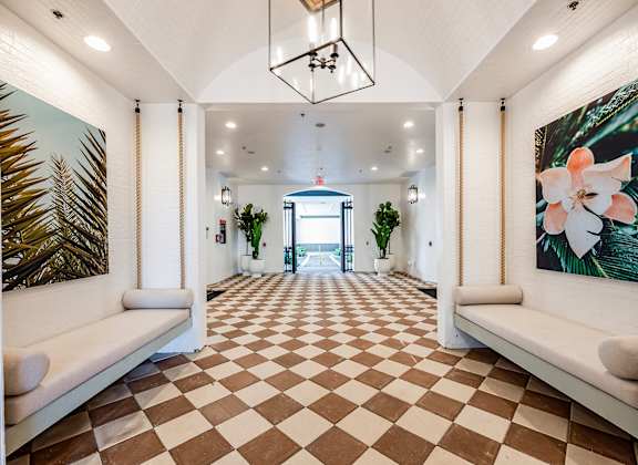 A long hallway with a checkered floor and white walls.