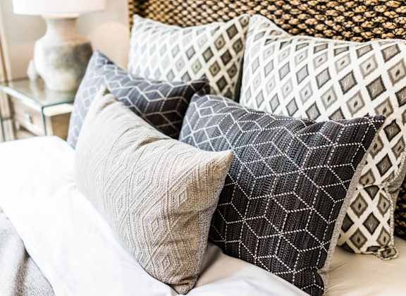 a pile of pillows on top of a bed