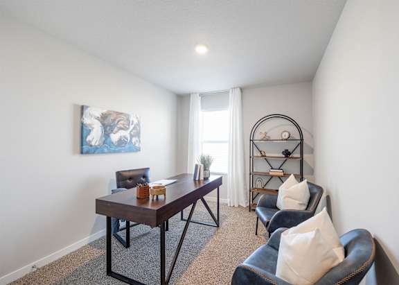 A room with a table, chairs and a painting on the wall.
