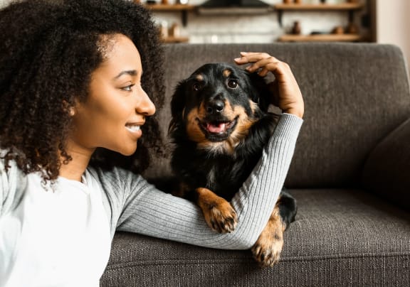 a woman sitting on a couch with her dog