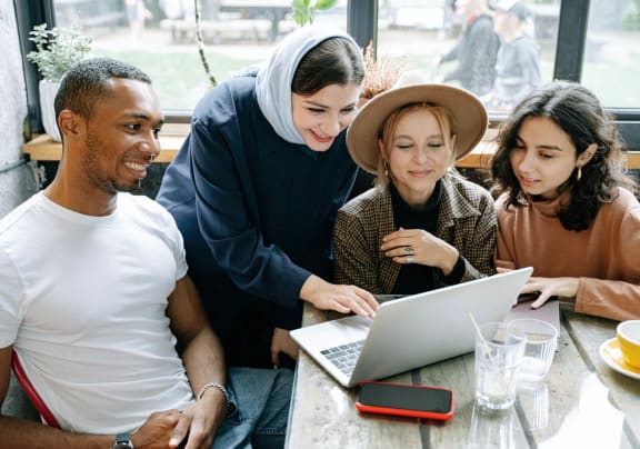 A Group of Young Professionals Looking at a Laptop
