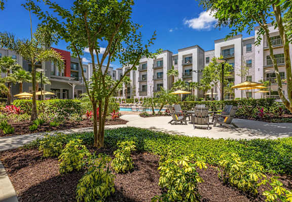 a courtyard with a table and chairs in front of an apartment building