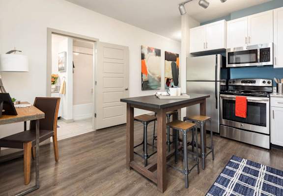 a kitchen with stainless steel appliances and a counter with stools
